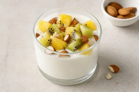 Imagen ilustrativa de Copa de yogur proteico con kiwi amarillo y almendras