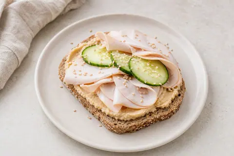 Imagen ilustrativa de Tostadas de hummus tradicional con virutas de pavo